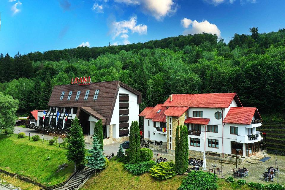 Vilele Domeniului de Poveste Lidana pe coasta dealului, înconjurate de pădure de brazi, la Vama