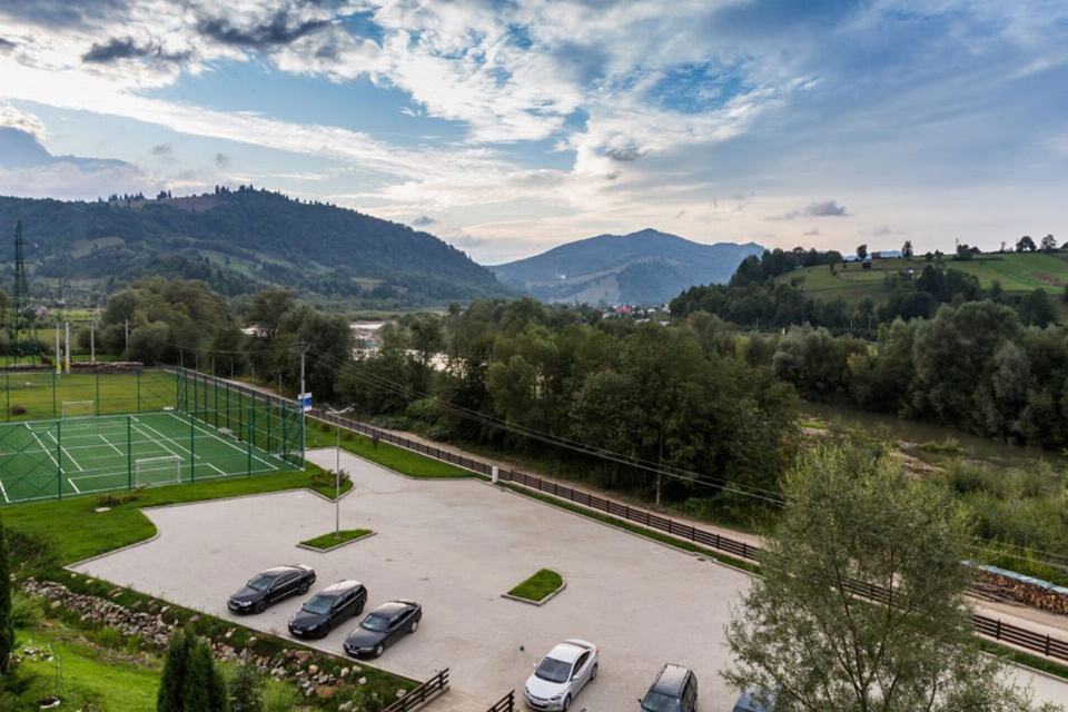Valea râului Moldova văzută de la Lidana, cu dealuri împădurite pe ambele maluri