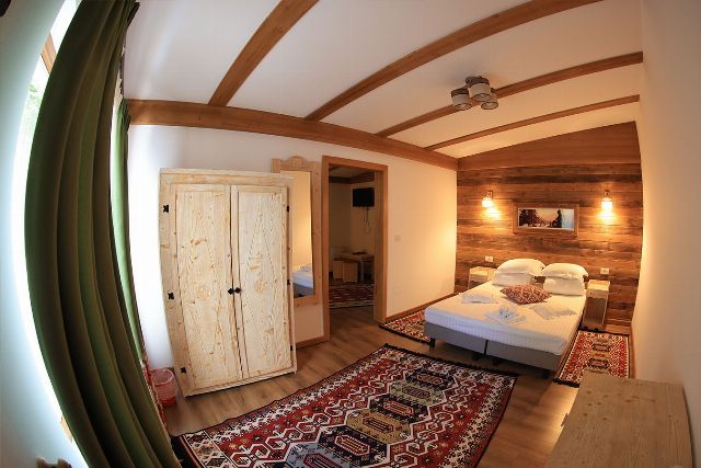Apartamentul 2 din Vila Rebeca, cu pat matrimonial și canapea extensibilă, veioze de perete și fereastră cu perdele deschise