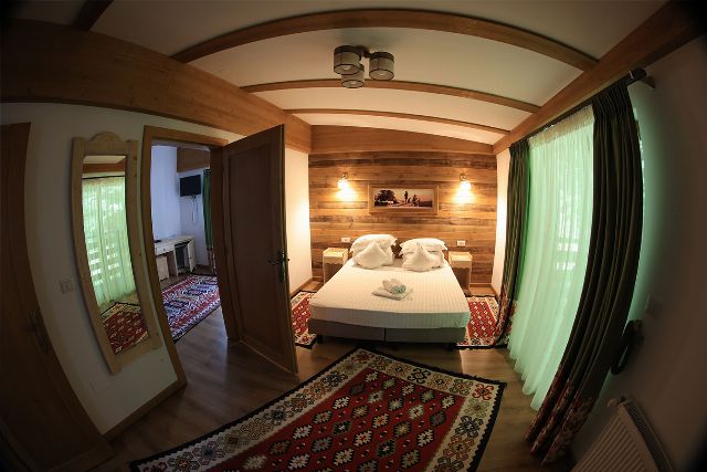Apartamentul 2 din Vila Rebeca, cu pat matrimonial și canapea extensibilă, birou de lemn și televizor cu ecran plat