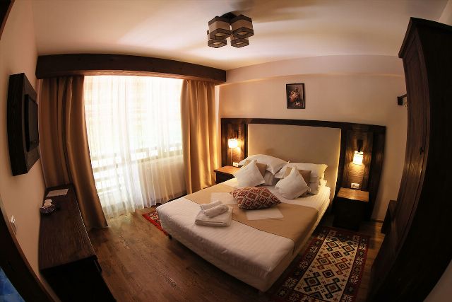 Camera 4 din Vila Rebeca, cu pat matrimonial, birou de lemn și televizor cu ecran plat