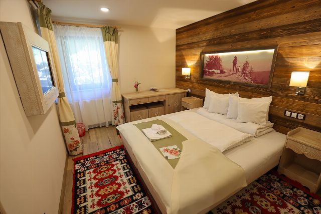 Camera 3 din Vila Savel, cu două paturi twin, veioze de perete și fereastră cu perdele deschise