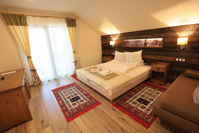 Camera 5 din Vila Savel, cu două paturi twin și canapea, lângă fereastra spre pădure